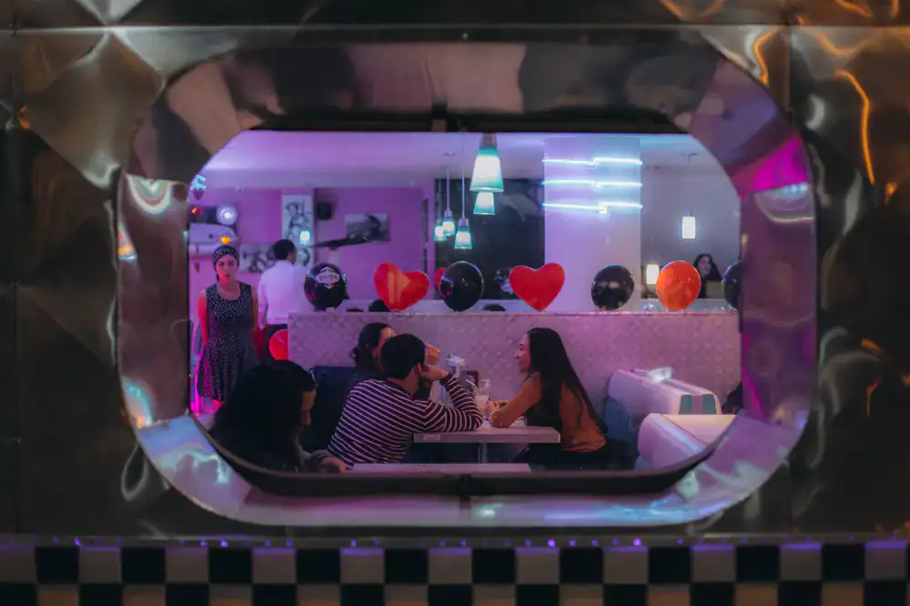 A retro diner booth illuminated by neon arcade lights