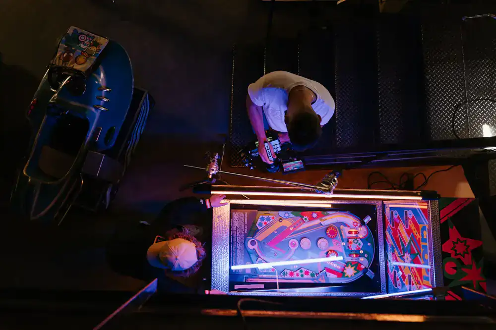 Glowing vintage arcade and pinball machines in a dark café