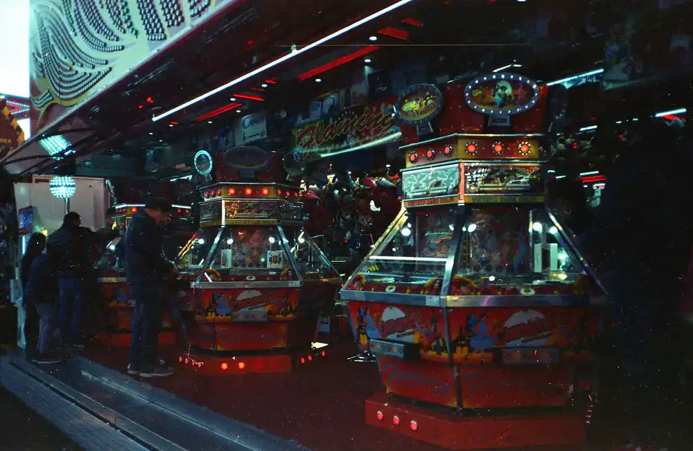 Row of glowing vintage pinball machines in a dark room