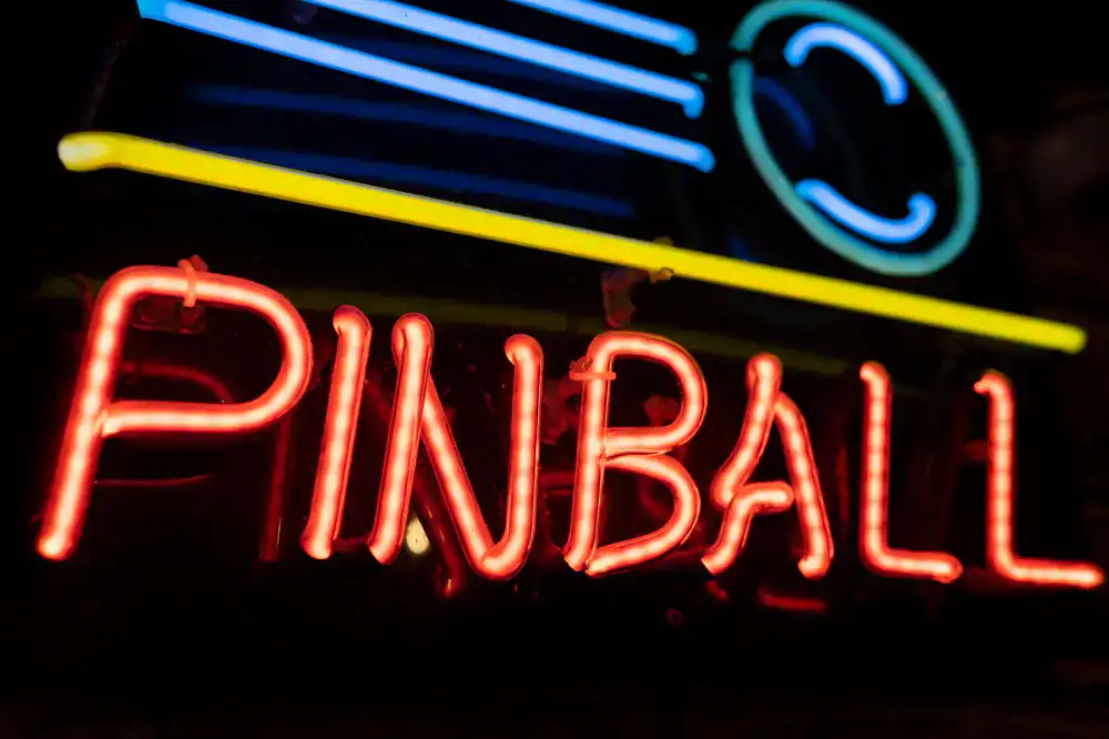 Glowing neon sign pointing to the vintage arcade entrance